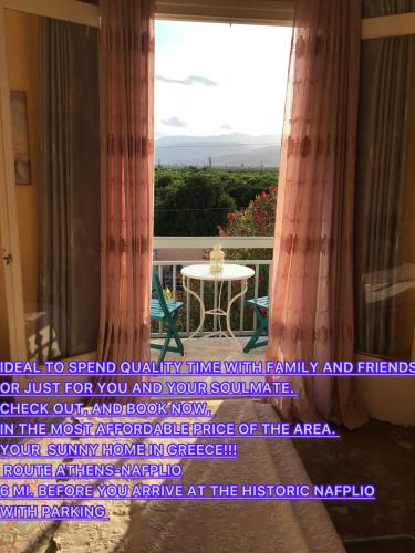a balcony with a table and a large window at Lidas Golden View-All around veranda apartment in Nafplio