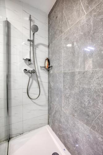 a bathroom with a shower with a glass door at Elegant seafront apartment in St. Julianʼs