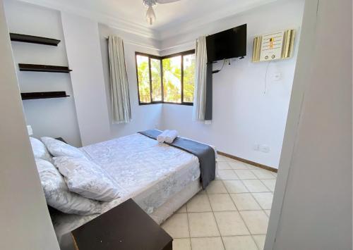 a bedroom with a bed and a tv in it at Apartamento recantoazul es Conforto Total a 50m do Mar Apartamento Recém-Reformado na Praia de Castelhanos, ES, para 7 Pessoas Aconchegante e Completo, com 3 Quartos e 1 Suíte in Anchieta