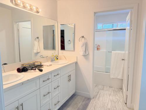 a white bathroom with two sinks and a shower at Modern Luxury House 3B&4B House 30 mins DTLA in Baldwin Park