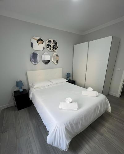 a bedroom with a large white bed with two towels on it at Grey House in Huelva