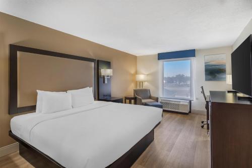 a hotel room with a large bed and a desk at Best Western Plus Madison in Madison