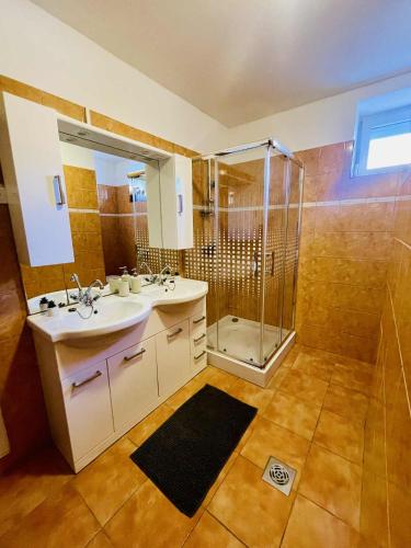 a bathroom with a shower and a sink and a showerspective at Bükk-Völgye Vendégház in Bogács