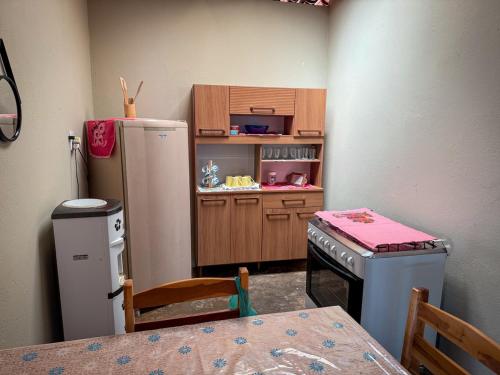 una cocina con nevera y mesa y silla en Chácara Serra Dourada, en Mulungu