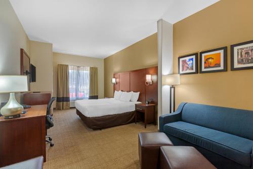 サバンナにあるComfort Suites Savannah Gateway I-95のベッドとソファのあるホテルの部屋