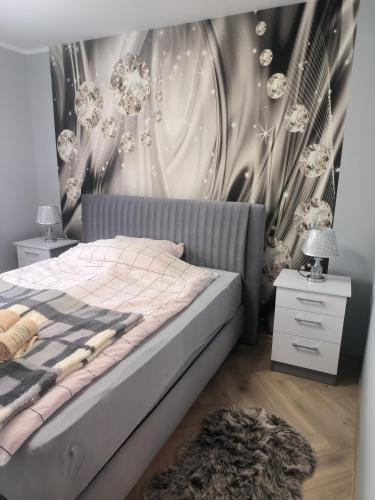 a bedroom with a bed and a wall with flowers at Apartament Mońki - Gold Center in Mońki
