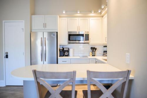 a white kitchen with a table and two chairs at Coastal Luxury Studio One Block to Big Rock in Morehead City