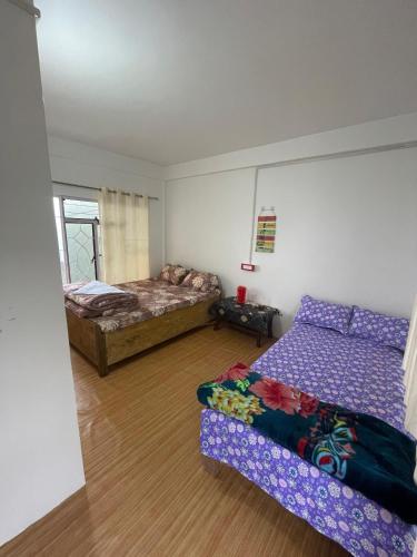 a bedroom with two beds and a couch in it at The Jhandi Nest in Gorubathān
