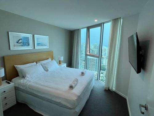 une chambre avec un grand lit et une grande fenêtre dans l'établissement 5-star, 3-bdrm apt on Surfers Paradise beach, à Gold Coast