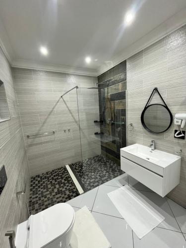 a bathroom with a toilet and a sink and a shower at 98 Inn Guesthouse Two Bedroom Apartment in Jacksonʼs Drift