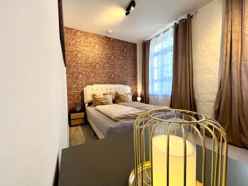 a bedroom with a bed and a brick wall at Industrial feeling in a quiet location in Leipzig