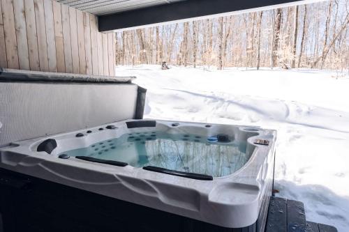 a jacuzzi tub in a snow covered yard at Le coup de coeur du Lac Supérieur - 3 minutes from Tremblant! in Lac-Superieur