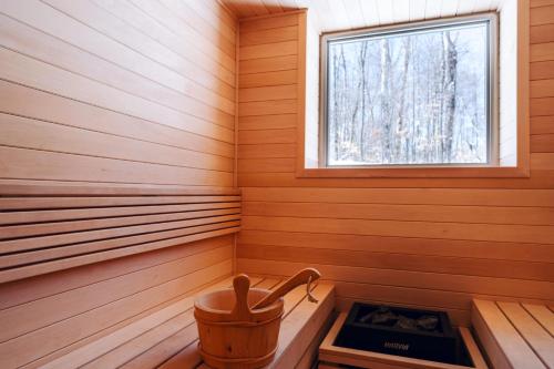 a sauna with a bucket and a window at Le coup de coeur du Lac Supérieur - 3 minutes from Tremblant! in Lac-Superieur