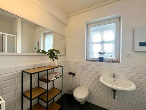 a white bathroom with a sink and a toilet at Industrial feeling in a quiet location in Leipzig