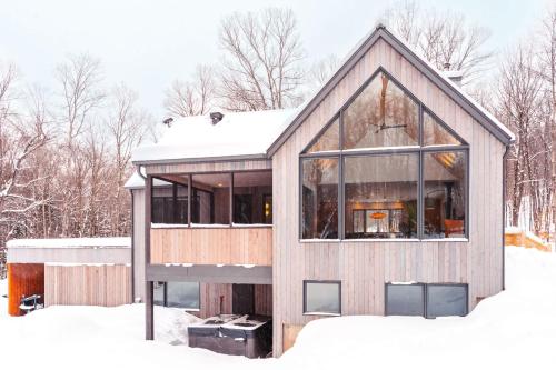 a house in the snow with glass at Le coup de coeur du Lac Supérieur - 3 minutes from Tremblant! in Lac-Superieur