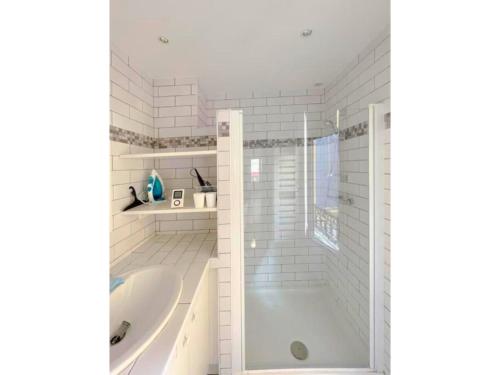 un bagno bianco con vasca e lavandino di La Clé de Pierre a Saint-Germain-en-Laye