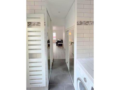 bagno bianco con lavatrice e asciugatrice di La Clé de Pierre a Saint-Germain-en-Laye