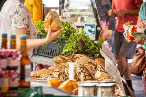 a woman holding a sandwich in front of a food stand at L'étoile des remparts in Lagrasse