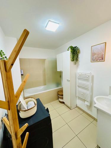 a bathroom with a sink and a bath tub at Le Cocon des Thermes Amneville Metz Luxembourg in Amnéville