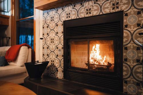 een open haard in de woonkamer bij Be zen with nature & enjoy private hot tub in Lac-Superieur