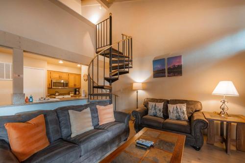 a living room with a couch and a spiral staircase at Lakeland Sandy Beach Retreat - Private Escape in South Lake Tahoe