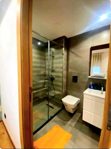a bathroom with a shower and a toilet and a sink at Appart Ennakhil 4 avenue mohamed 6 in El Jadida