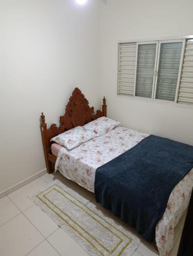 a bedroom with a bed with a blue blanket at Apartmento duplex in Araxá