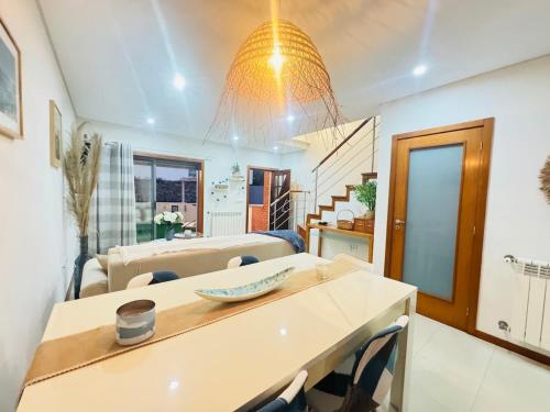 een keuken en een woonkamer met een kroonluchter bij Beach House in Fão