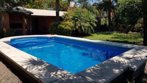 una piscina en un patio con una casa en Casaquinta con Piscina a Cuadras de la Playa, en Paso de la Patria