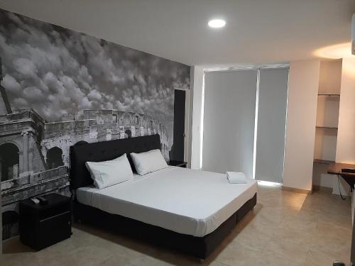 a bedroom with a bed with a painting on the wall at Hotel Fenix in Cúcuta