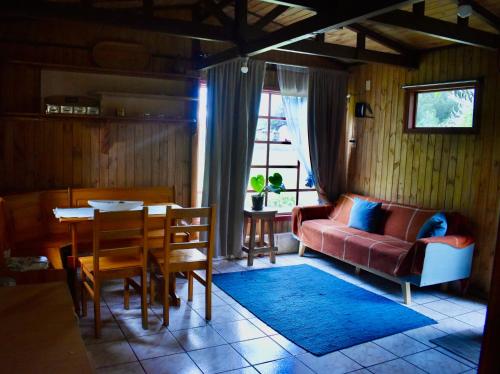 een woonkamer met een bank en een tafel bij Casa Maqui Salto del Laja in Salto del Laja