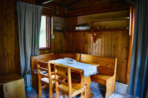 een houten eetkamer met een tafel en stoelen bij Casa Maqui Salto del Laja in Salto del Laja
