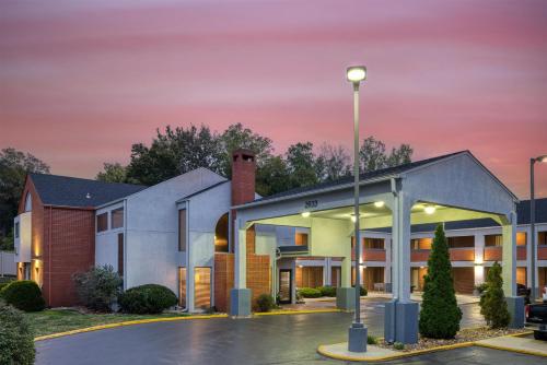 a building with a light pole in a parking lot at SureStay by Best Western Kansas City Country Inn North in Kansas City
