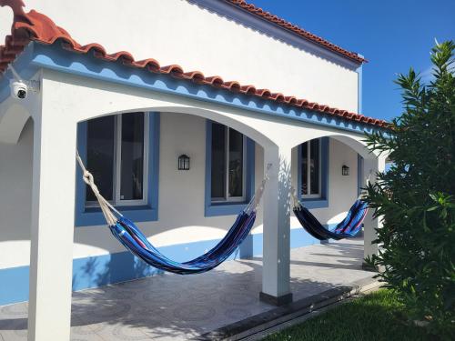two hammocks hanging from a porch of a house at Oceanview Sunset Retreat in Pilar