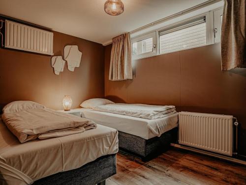 a bedroom with two beds and a window at Houseboat in Netherlands with Private Dock in Uitgeest