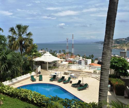 a view of a pool and the ocean from a resort at Villa Costa Chica Comodisimo piscina gigante jardines in Acapulco