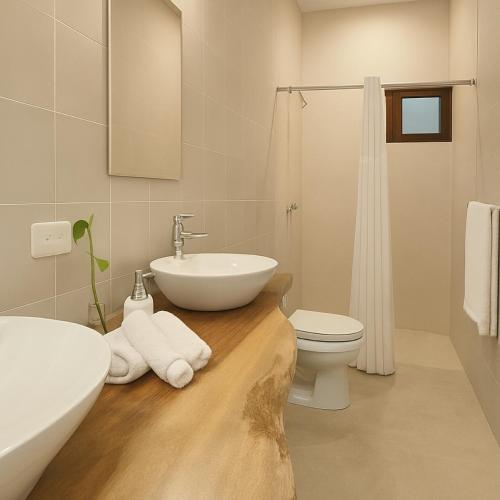 a white bathroom with a sink and a toilet at DezMont Guest House in Mérida