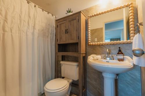 a bathroom with a toilet and a sink and a mirror at Marena Seaview Condo in Dos Marinas, Fajardo in Beltran