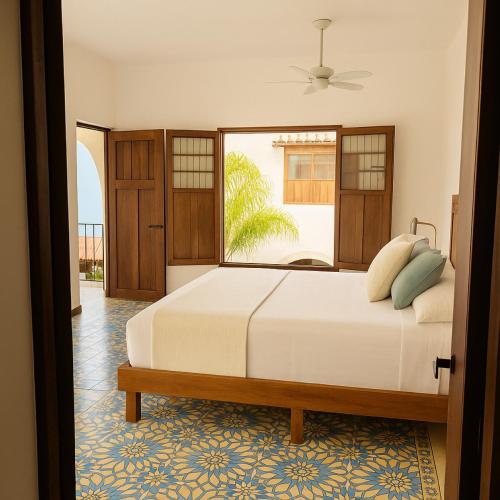 a bedroom with a bed and a large window at DezMont Guest House in Mérida