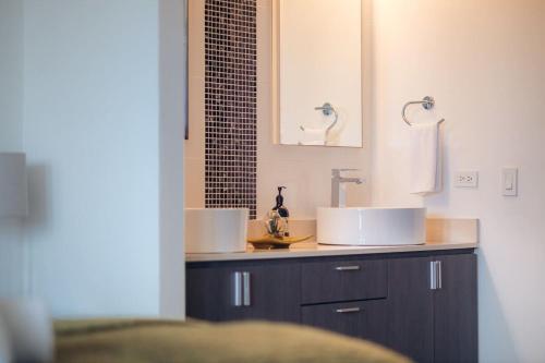 a bathroom with two sinks and a mirror at Selah | Travelers Nesters in Palmas Del Mar in Buena Vista