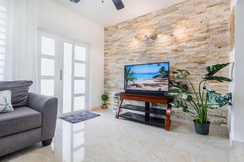 MameyesBlü Zen, Ideal Couple’s Stay in Mameyes Rio Grande的一间客厅,在砖墙上配有电视