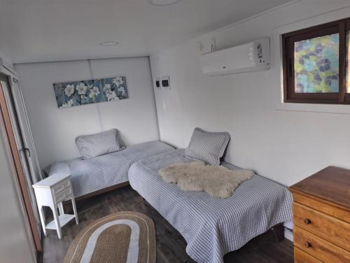 a small room with two beds and a window at Hostal Boutique "Maryluz" in Coihaique