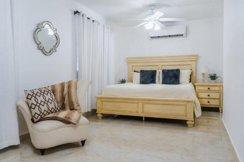 ein Schlafzimmer mit einem Bett und einem Stuhl in der Unterkunft Blü Zen, Ideal Couple’s Stay in Mameyes Rio Grande in Mameyes
