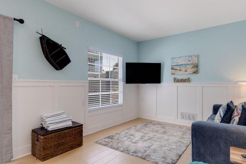 een woonkamer met een bank en een tv bij Gorgeous Apartment on Mango St Steps to Beach in Fort Myers Beach