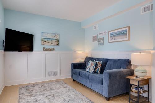 een woonkamer met een blauwe bank en een tv bij Gorgeous Apartment on Mango St Steps to Beach in Fort Myers Beach
