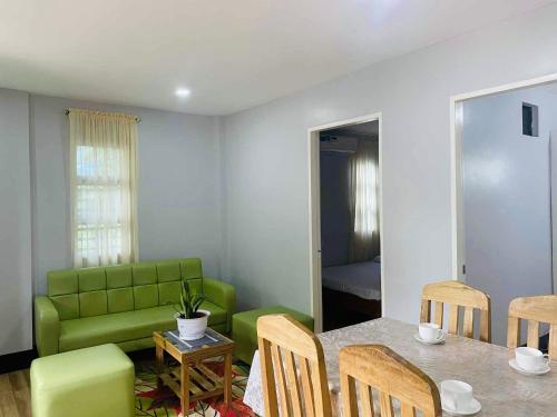 a living room with a green couch and a table at 2K2M Rental Units in Panglao