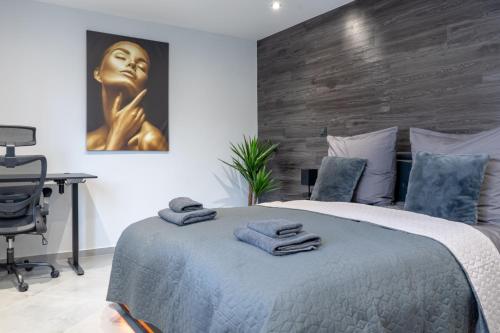 a bedroom with a bed with a desk and a painting at Luxury Apartment Schwabach 2 in Schwabach
