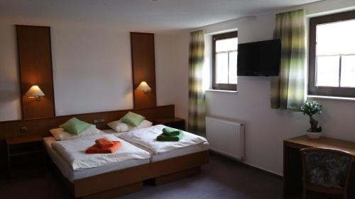 a bedroom with a bed with two towels on it at Hotel Am Markt in Ehrenfriedersdorf