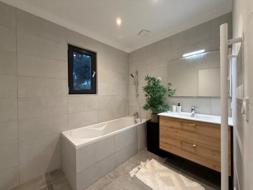 a bathroom with a tub and a sink and a mirror at Modern house 4 bedrooms in Tassin-la-Demi-Lune