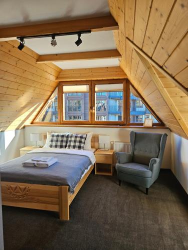 a bedroom with a bed and a chair at Miętusi Dwór in Zakopane